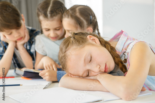 Young girl looking bored studying at school