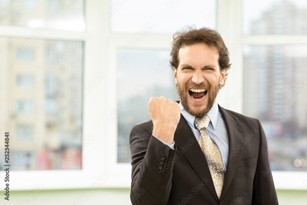 Mature bearded businessman screaming happily in the office Mature bearded businessman screaming happily in the office
