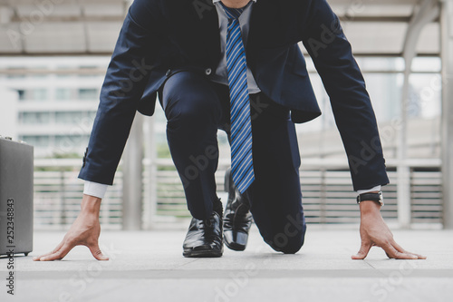 Businessman set in start running position prepare to fight in business race.