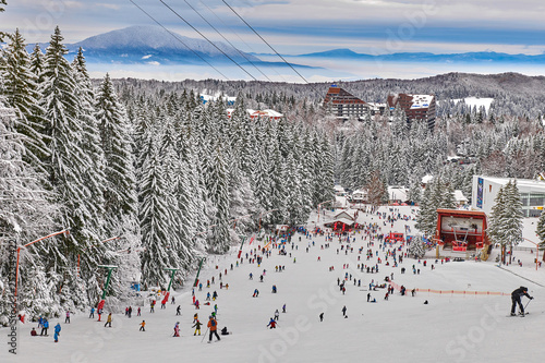 Poiana Brasov, Romania -16 January 2019: Skiers and snowboarders enjoy the ski slopes in Poiana Brasov winter resort whit forest covered in snow