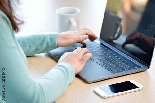 Cropped shot of an unrecognizable businesswoman using a laptop in her home office © cunaplus