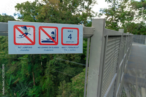 A warning sign installed at the canopy walkway in a botanical garden to prevent the visitors from danger.