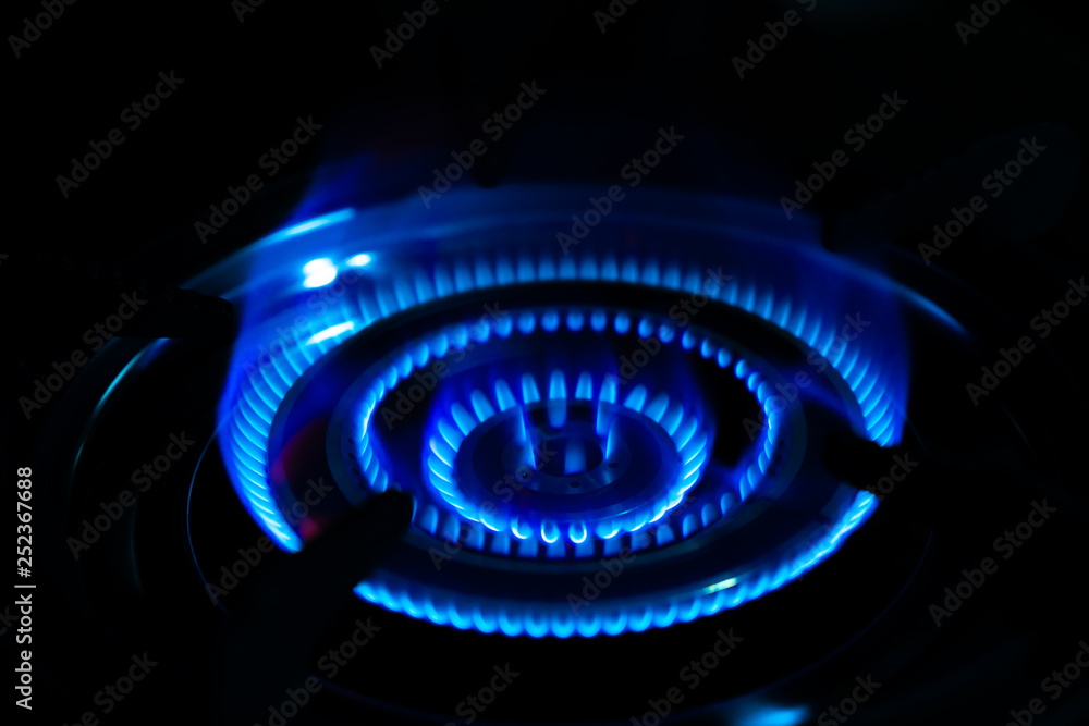 Blue of fire burning in kitchen on the dark background.