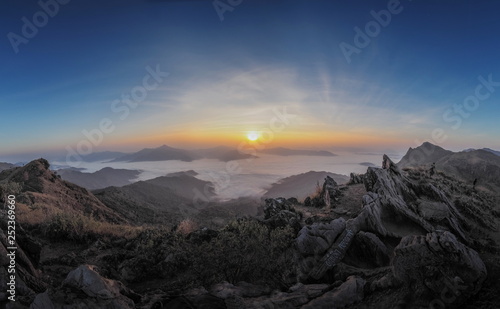 sunrise at Doi Pha Tang, mountain view misty morning on top hill around with ocean of mist above Mekong river with colorful red and yellow light in the sky background, Phatang, Chiang Rai, Thailand.
