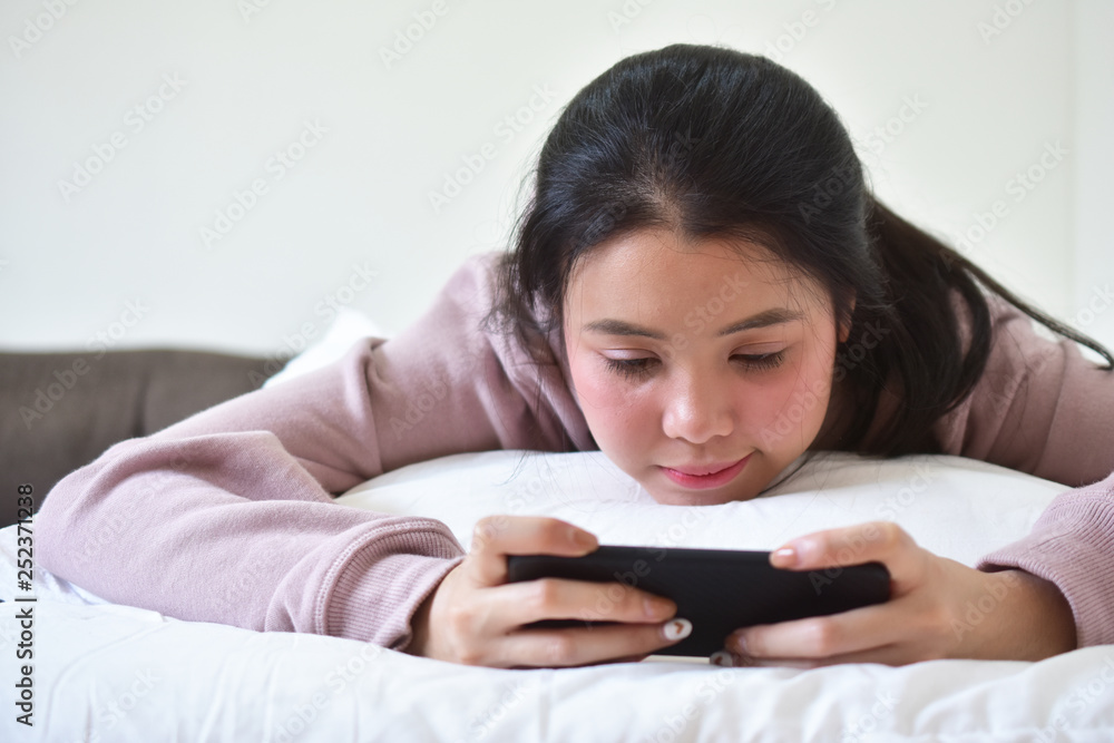Women using mobile smartphone is ion bedroom Women using mobile smartphone is ion bedroom
