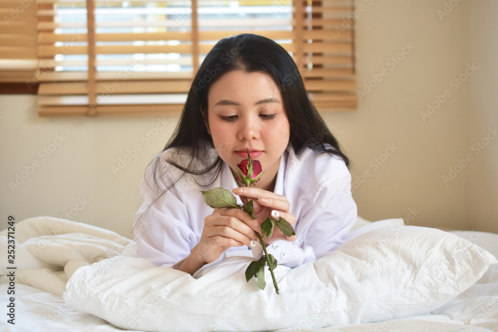 Young beauty women with rose flower is on bedroom Young beauty women with rose flower is on bedroom
