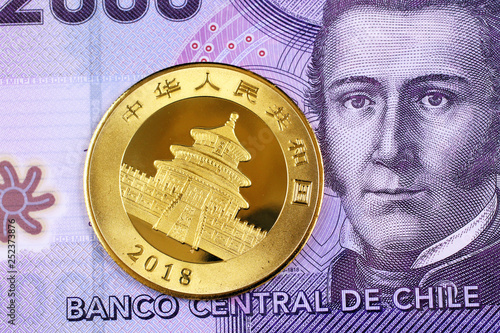 Photography A purple Chilean two thousand peso bill with a Chinese one ounce gold coin close