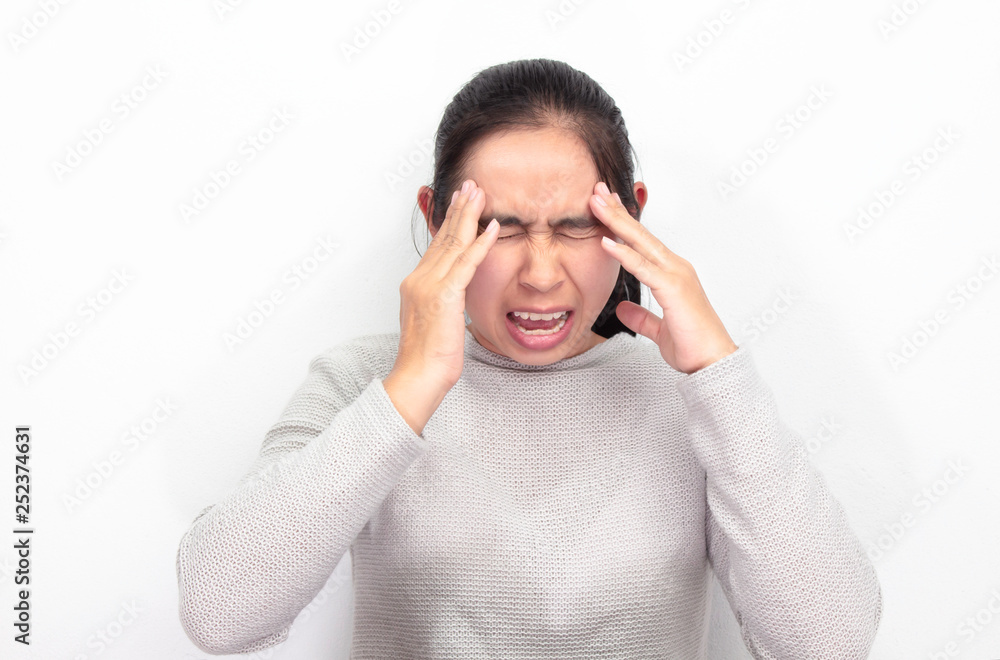 Naklejka premium Portrait of Asian woman sitting at her room, white wall. She have a headache and stressed. Health care concept. Space for text input.