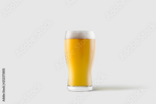 Cold mug of light beer with foam isolated on soft gray background.