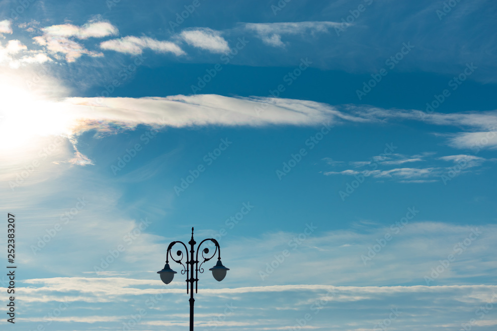 Lantern in winter against the blue sky with clouds and sunshine Lantern in winter against the blue sky with clouds and sunshine