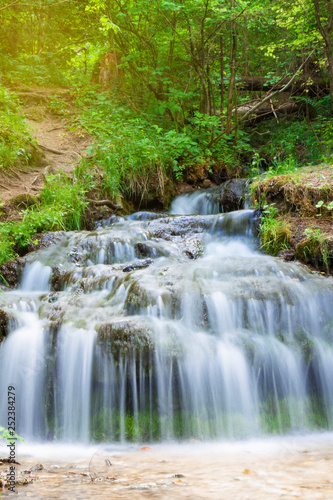 Fototapeta Naklejka Na Ścianę i Meble -  Small forest waterfall in the summer, closeup