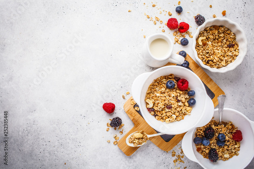 Breakfast food background. Granola with milk and berries on white table.