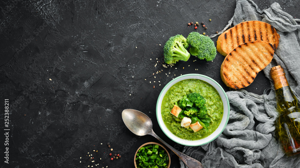 Broccoli, spinach cream soup in a bowl with toasted bread. Green soup. Dietary food. Top view.