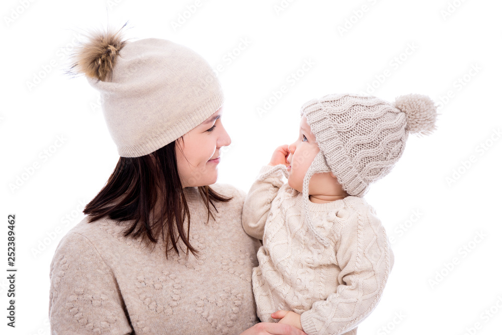 young mother and cute baby daughter in winter clothes looking at each other isolated on white young mother and cute baby daughter in winter clothes looking at each other isolated on white