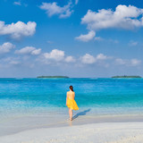 Woman in dress walking on tropical beach