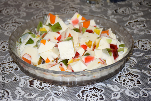 Gelatin Dessert Homemade on cakestand on light background. Glaze dessert for kids and adults. Multicolored gelly cut into square pieces on a big plate. photo