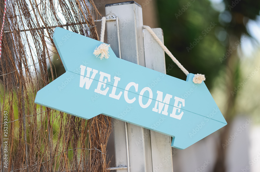 Cartel con orma de flecha con la palabra bienvenido en inglés foto de