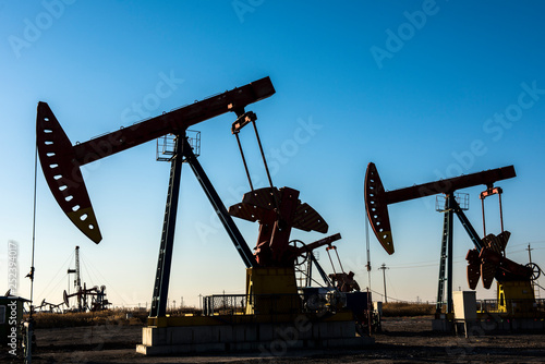 Oil pumps are running in the sunset at the oil field. On the Bohai coast of China.