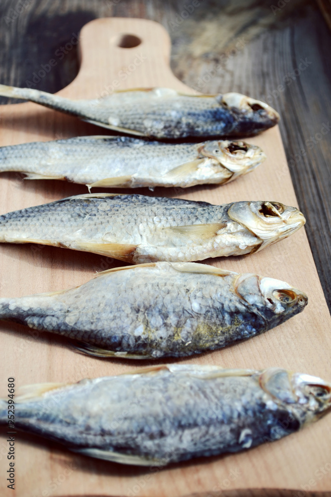 Salty stockfish cod on wooden board with gaarlic and pepper Salty stockfish cod on wooden board with gaarlic and pepper