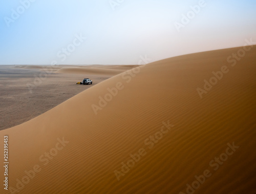 Desert atmosphere in the morning in the desert Sahara in Sudan on a big sand dune with the tent and the jeep in the background  Africa