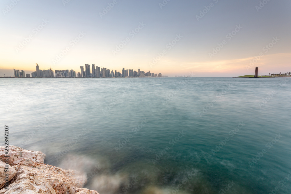 Doha skyline with calm wave of sea water