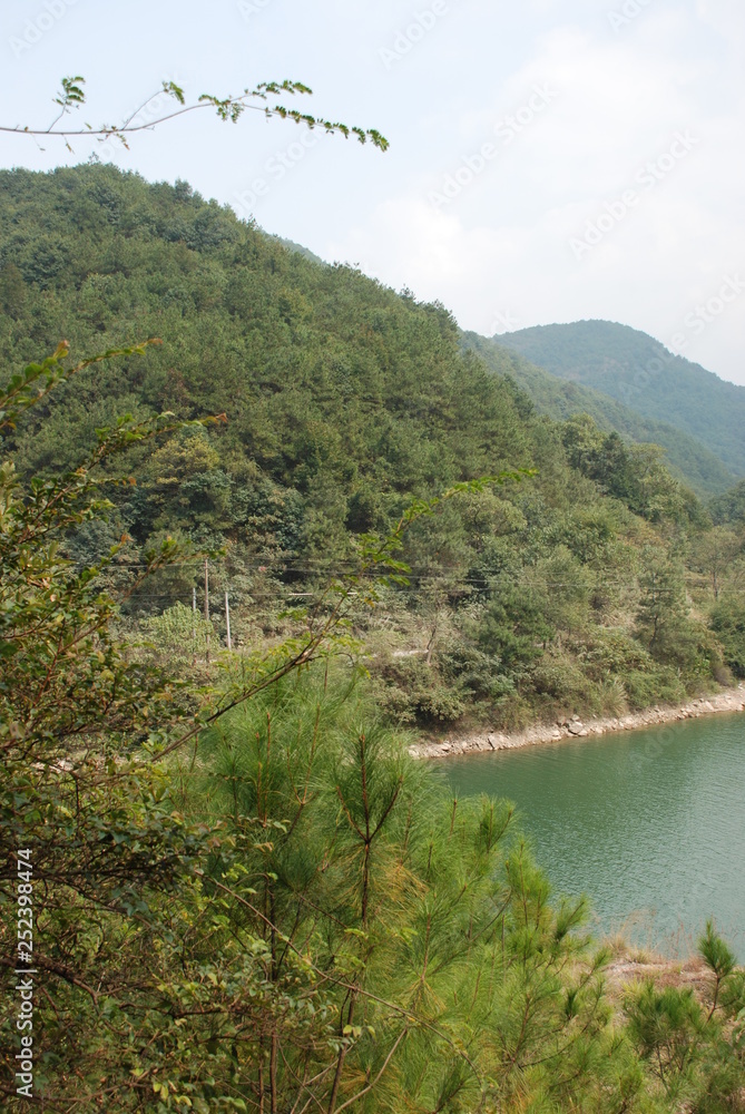 Turquoise green lake surrounded with green mountains in Asia, China Turquoise green lake surrounded with green mountains in Asia, China