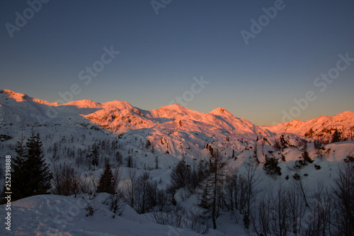 Sunset in snowcaped mountains. Mountains are orange color. Slovenia, Juliana Alps, Komna. The paradise for ski touring.