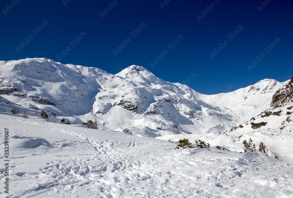 Beautiful Winter Landscape of the Mountain covered with snow under the blue and clear sky and snow field. Ski touring and snoshoeing paradise. Slovenia, Julian Alps, Komna