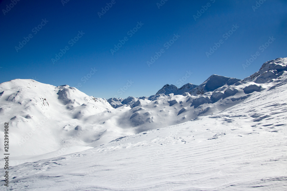 Beautiful Winter Landscape of the Mountain covered with snow under the blue and clear sky and snow field. Ski touring and snoshoeing paradise. Slovenia, Julian Alps, Komna