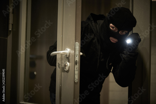 Burglar thief in mask. break-in of an apartment. photo