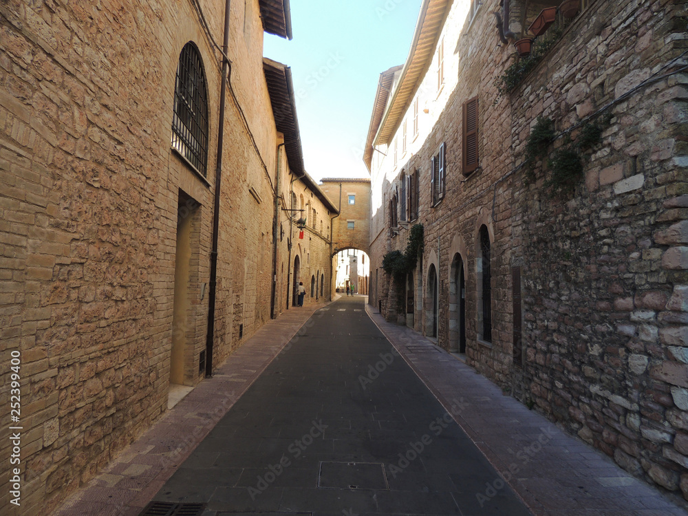 Alley with ancient buildings in Assisi, Umbria, Italy.