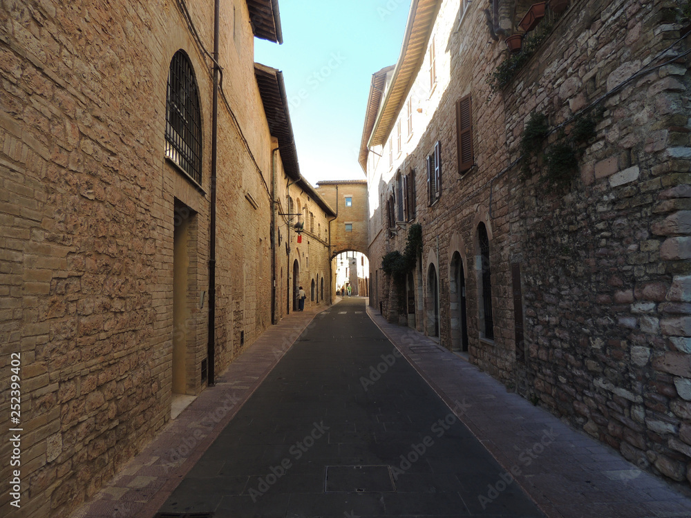 Alley with ancient buildings in Assisi, Umbria, Italy.