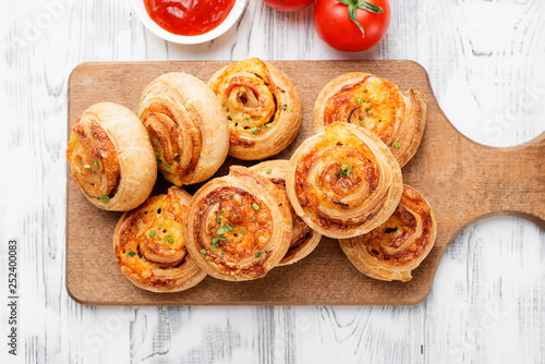 Fotografie Rolls of puff pastry with bacon and cheese .