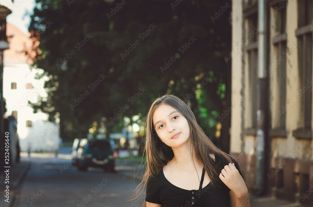 Cute young girl without makeup on the background of a beautiful old building.