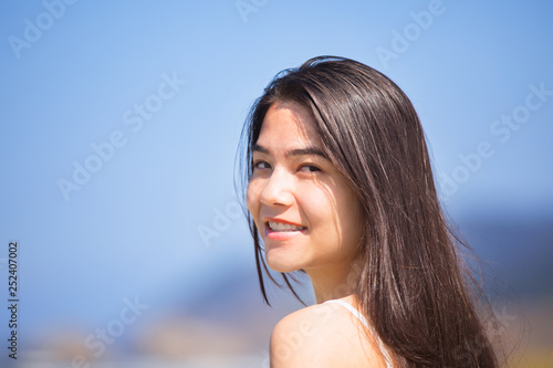 Beautiful teen girl at beach on sunny day, smiling