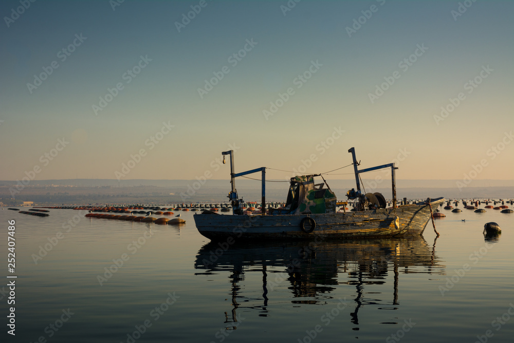 Wooden Boat Moored Among Mussel Plantation in the Mar Piccolo in Taranto in the South of Italy at Sunrise