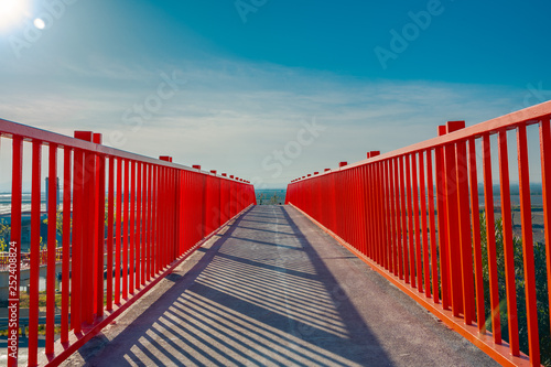 Small red bridge close up. Red fences. Metal bridge over the highway.