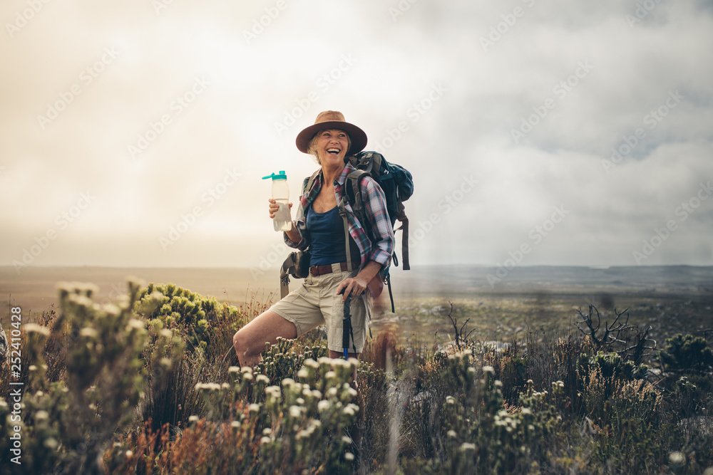 Female hiker relaxing during a trek - obrazy, fototapety, plakaty 