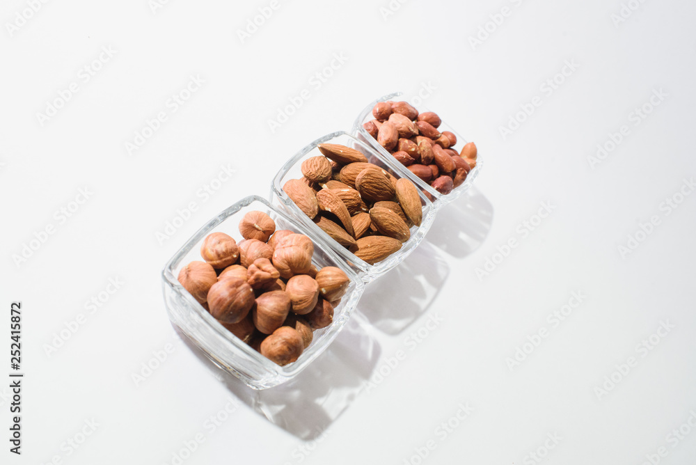 Peanuts, hazelnuts and almonds on a white background Peanuts, hazelnuts and almonds on a white background