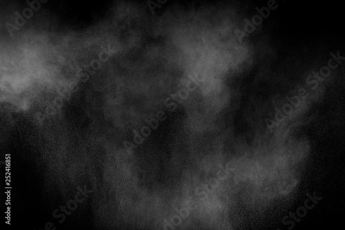 Bizarre forms of white powder explosion cloud against black background.White dust particles splash.