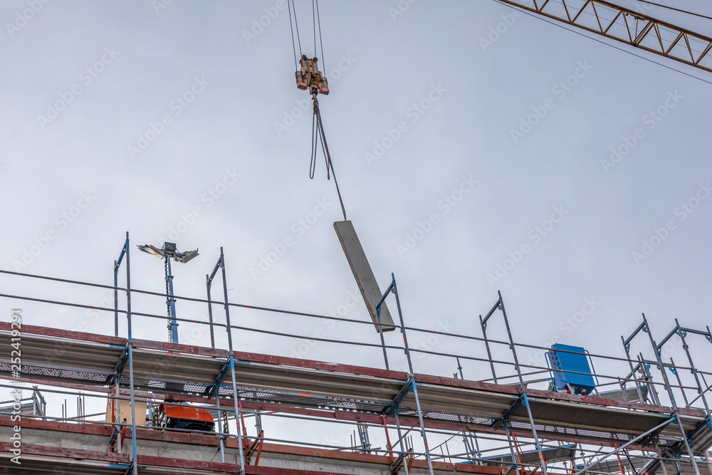 Schalungselement am Kran schwebt über der Baustelle Schalungselement am Kran schwebt über der Baustelle