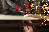 Industrial worker cutting metal at the factory