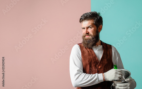 Smiling butler with bottle of wine in bucket. Butler in high class restaurant serving wine or champagne. Waiter holds wine cooler with bottle of champagne. Waiter with ice bucket with champagne bottle © Svitlana