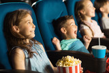 Group of happy kids enjoying a movie at the cinema