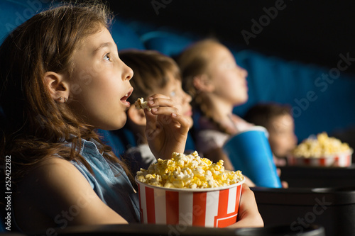 Group of happy kids enjoying a movie at the cinema photo