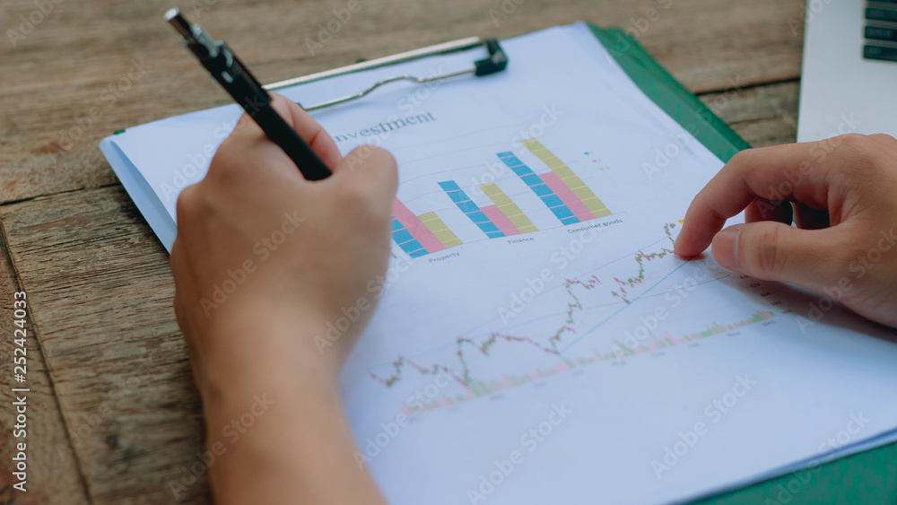 Young architects are analyzing the stock chart in the company. Young architects are analyzing the stock chart in the company.