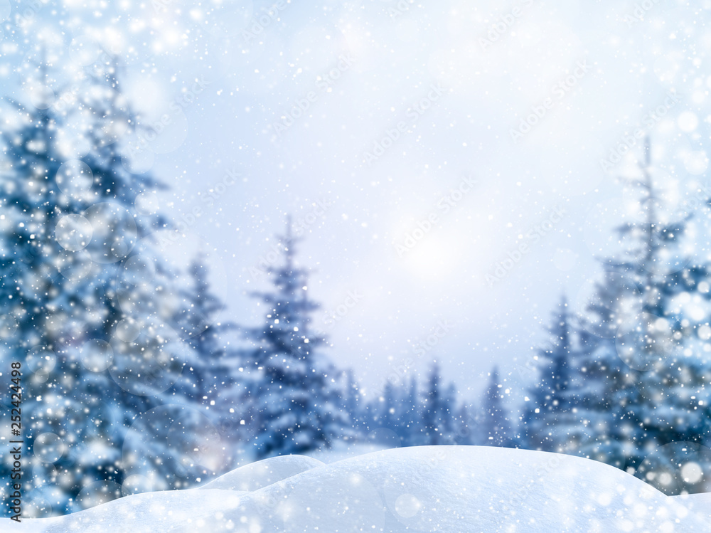 Winter Christmas scenic background with copy space. Blurred snow landscape with spruce branches covered with snow and glowing bokeh falling snow.