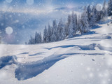 Winter Christmas scenic snow landscape, with falling snow and bokeh soft highlights over a mountains blurred background.