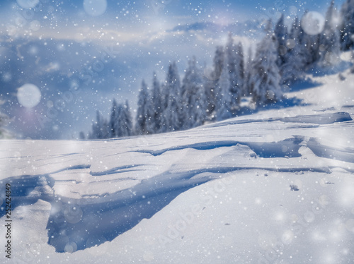 Winter Christmas scenic snow landscape, with falling snow and bokeh soft highlights over a mountains blurred background.