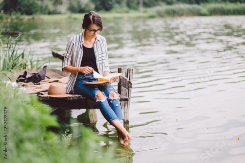 Learning / reading woman concept at summer lake